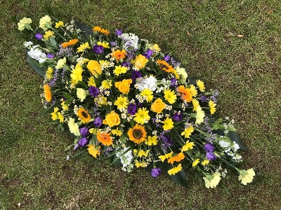 Purple, yellow and white casket spray