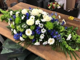 Blue and green casket spray